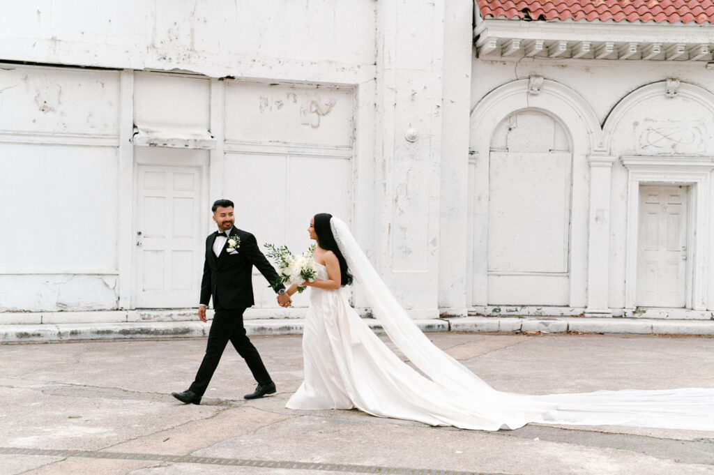 Bride and groom walking hand in hand in downtown Richmond during their Common House Richmond wedding, photographed by Chelsea Schmidt Photography.