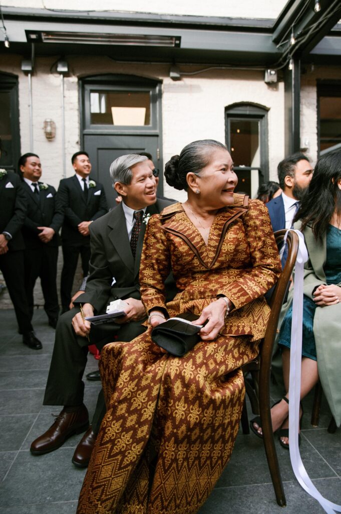 Wedding guests seated and smiling before the ceremony begins at Common House Richmond.